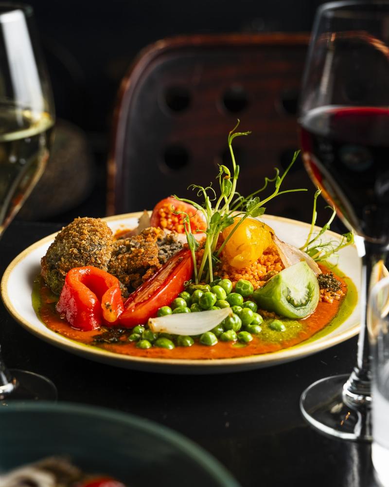 Chef présentant une assiette raffinée dans un restaurant art de vivre